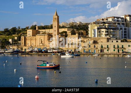 View across the harbour at Marsaskala to Saint Anne's church, Malta Stock Photo