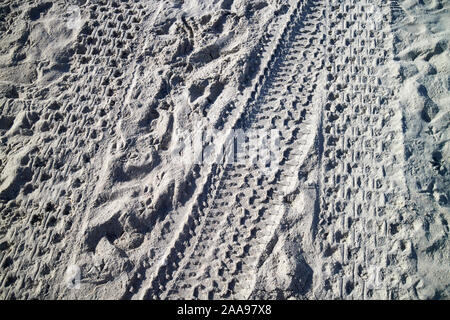 car and atv tire tracks in white northern florida sand on a beach florida usa Stock Photo