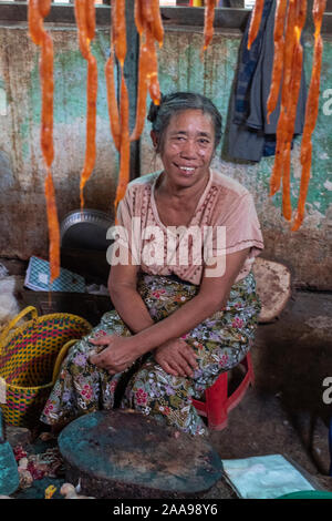 The lively meat,fish,vegetable & fruit market of Pakokku, Myanmar (Burma) with an older woman selling fresh sausage Stock Photo
