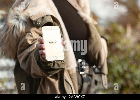 16. November 2019, Schwäbisch Gmünd, Germany: Woman holding a phone in the hands. Amazon logo on the cellphone screen Stock Photo