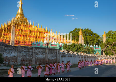 A procession of Buddhist nuns dressed in pink robes head to the Thanboodi (Moe Hnyin Than Boaddai) Temple in Monywa, Myanmar (Burma) for prayers. Stock Photo