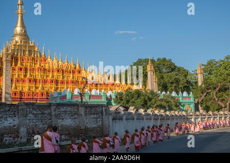 A procession of Buddhist nuns dressed in pink robes head to the Thanboodi (Moe Hnyin Than Boaddai) Temple in Monywa, Myanmar (Burma) for prayers. Stock Photo