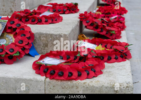 Red poppy wreathes laid around a War memorial on Remembrance Sunday Stock Photo