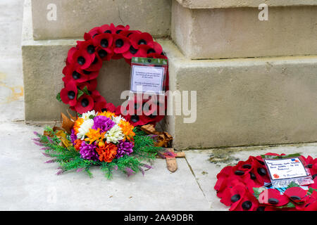 Red poppy wreathes laid around a War memorial on Remembrance Sunday Stock Photo