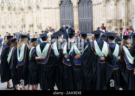 A line of male and female York St John University Students posing for photographs on their graduation outside of York Minster, North Yorkshire, UK. Stock Photo