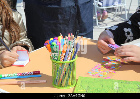 view of a set of colored pencils . colored pencils on the wooden background. Place for text . Pens and pencils in metal holder in front of wooden back Stock Photo