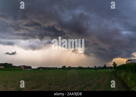 Dramatic sky as threatening storm clouds are moving fast over the landscape of Flanders, Belgium. Stock Photo