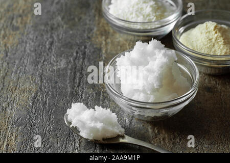 organic virgin coconut oil in glass bowl along with a spoonful of coconut oil. Stock Photo