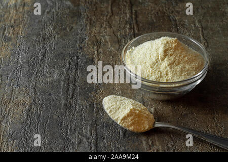 organic coconut flour in glass bowl along with a spoonful of coconut flour. Stock Photo