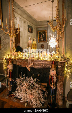 Christmas Decorations Hanging From Chandelier Above Table Laid For