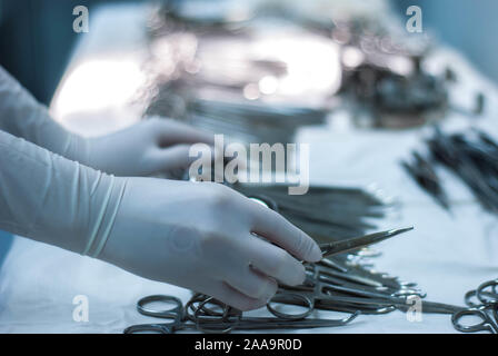 Veterinarians are using knives and scissors to cut a dog's wound. Surgeon at work in operating room. Hand of veterinarian surgery in operation room. W Stock Photo
