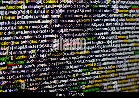 Macro photo of computer screen with program source code and highlighted HIJACKER inscription in the middle. Script on the screen with virus in it Stock Photo