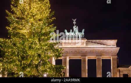 Illuminated Neoclassical Brandenburg Gate (Brandenburger Tor) and Christmas Tree as viewed from the Pariser Platz, Mitte, Berlin, Germany Stock Photo