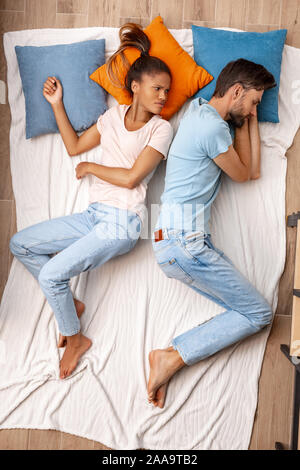 Young adult couple lying on bed together Stock Photo