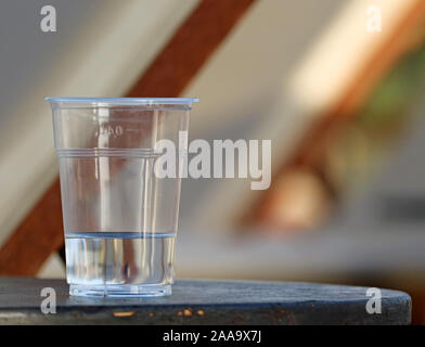 transparent plastic cup of water on table with copy space Stock Photo