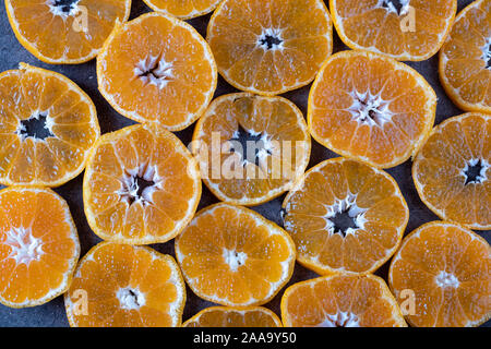 Round pieces of tangerine on dark background. tangerine texture Stock Photo
