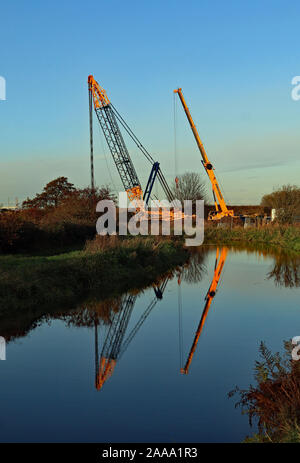 Ainscough’s crane hire company are busy building a large crane in a field next to the Leeds and Liverpool canal near Burscough in West Lancashire Stock Photo