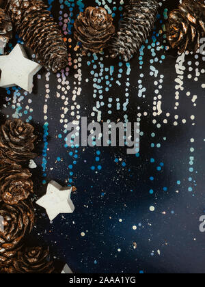 Photo of magic holographic rainbow colors, colorful iridescent surface. Holiday concept with cones and white stars. Colored glitter. Shining Stock Photo