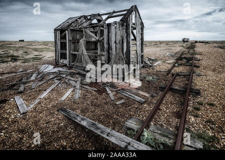 Abandoned old fishing hut and rail track on the shingle beach at Dungeness, Kent, England, UK Stock Photo