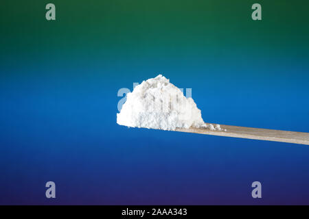 Flour that should look like a white drug with macro lens photographed in front of colorful gradient in the studio Stock Photo