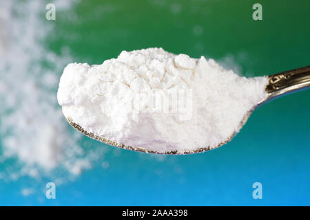 Flour that should look like a white drug with macro lens photographed in front of colorful gradient in the studio Stock Photo