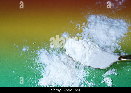 Flour that should look like a white drug with macro lens photographed in front of colorful gradient in the studio Stock Photo