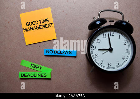 Good Time Management, no Delays and Kept Deadlines write on Sticky note. Isolated on wooden table Stock Photo