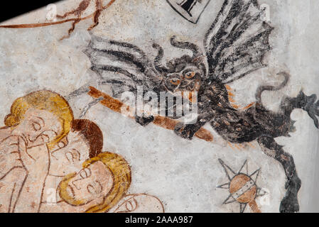 a flying devil with bat-wings attacks some people, a medieval fresco in Skibby church, Denmark, November 20, 2019 Stock Photo