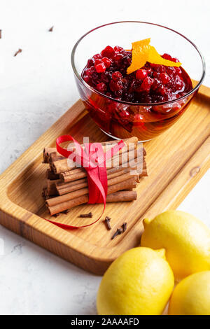 Thanksgiving cranberry sauce in glass bowl with fresh orange fruit and lemon ready to at Stock Photo