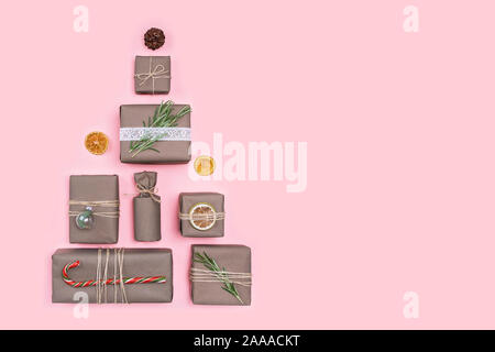 Christmas tree made of presents and gifts wrapped in craft paper. Flat lay. Holiday zero waste concept. Stock Photo