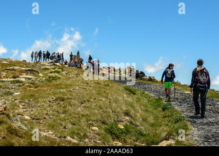 People hiking to the crowded peak of Mount Kosciuszko in Australia on a summer day Stock Photo