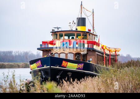 Classic steam ship with wooden paneling on the quay of a harbor with the festive decoration Stock Photo