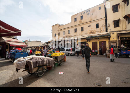 Fez, Morocco. November 9, 2019.  People walking between the fruit stalls on the street Stock Photo