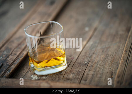 Glass with scotch on an old used wooden barrel Stock Photo