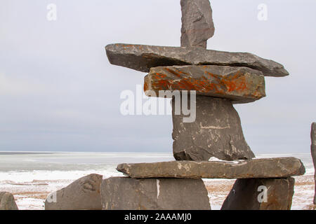 Inukshuk rock formation on banks of Hudson Bay in Churchill, Manitoba, Canada in winter. Stock Photo