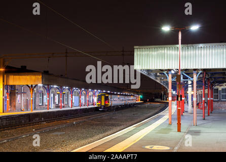 Abellio East Midlands railway class 158 sprinter train calling at Stockport station at night with a Peterborough - Liverpool train Stock Photo