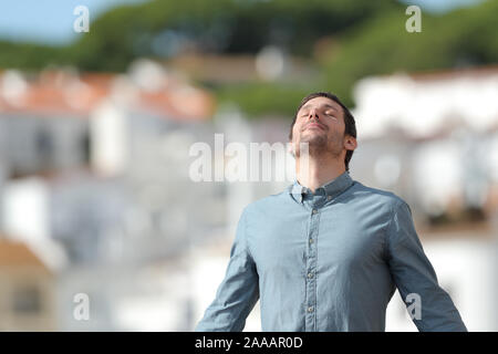Relaxed man breathing deep fresh air standing in a rural town a sunny day Stock Photo