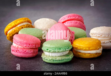 Pastel colored French macarons on a gray surface Stock Photo