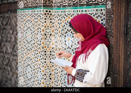 Young muslim woman reading a book Stock Photo