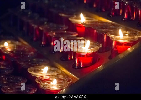Close-up of a lot of red candles in a church during a service, selective focus Stock Photo