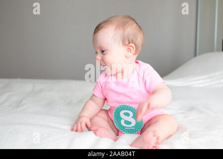 Close up Portrait of Cute 8 Month Old baby Girl with Big blue Eyes, Happy Baby Girl Stock Photo