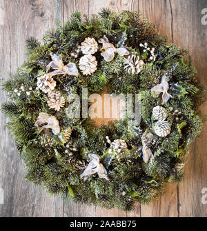 Christmas wreath with frozen pine cones and pines.Top View.  Advent reef with christmas theme on wooden background. Stock Photo