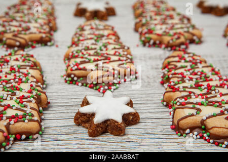 Christmas tree biscuits and almond stars dessert on white wood in perspective with shallow focus