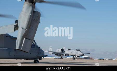 An A-10 Thunderbolt II, from the 124th Fighter Wing, taxis past an MV-22 Osprey from the Marine Medium Tiltrotor Squadron 362 (VMM-362), at Gowen Field, Boise, Idaho, Nov. 19, 2019. The 190th Fighter Squadron pilots and the VMM-362 Marines are training at the Saylor Creek Range south of Mountain Home, Idaho to enhance their combat search and rescue skillset. (U.S. Air National Guard photo by Senior Master Sgt. Joshua C. Allmaras) Stock Photo