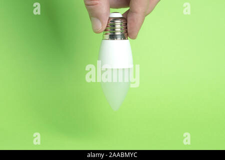 Eco power concept. LED bulb in hand on green background Stock Photo