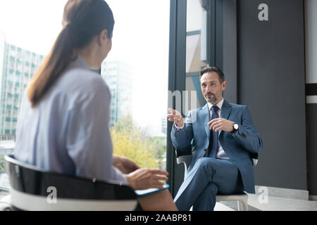 Businessman wearing elegant suit speaking with famous journalist Stock Photo