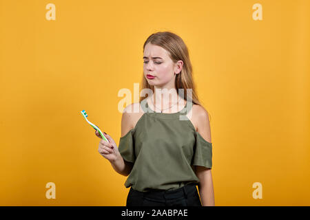 Beautiful young person looking on toothbrush. Looking shocked and exciting Stock Photo
