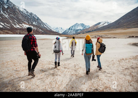 Group of young friends hikers are walking in mountains valley Stock Photo