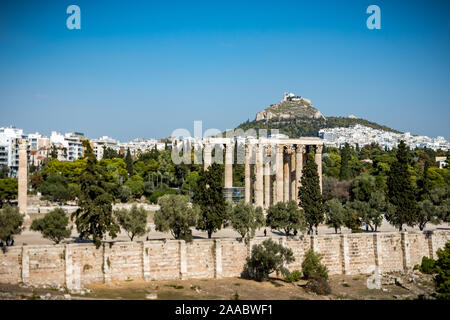 Athens, Greece: -October 28th, 2019: The Zeus columns as seen from central Athens with Lykabitos hill in the background. Stock Photo