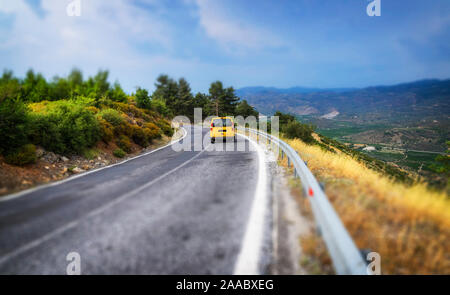 Road and yellow car top view with tilt shift effect. Stock Photo